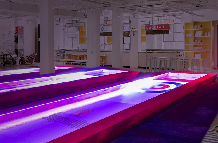 Two curling lanes illuminated at night.